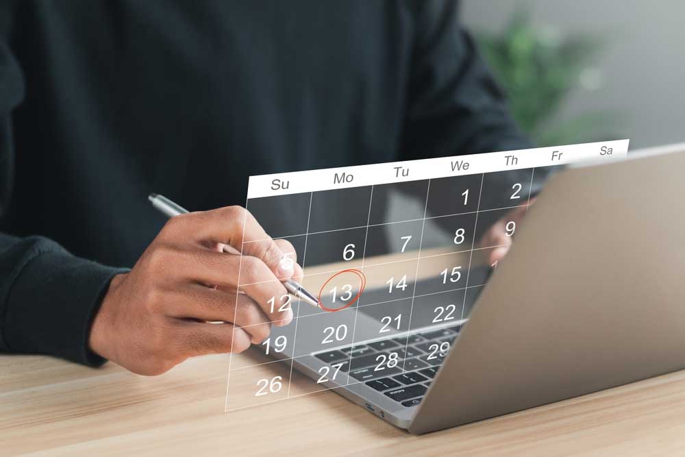 Person scheduling appointments on laptop calendar