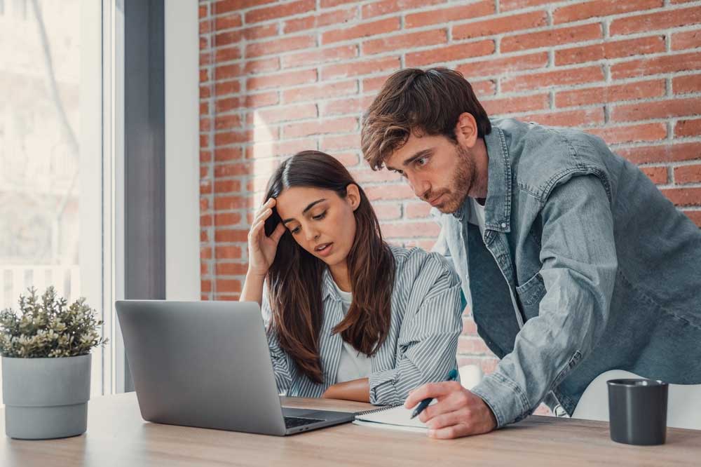 Two people in office looking at laptop - representing lost opportunities